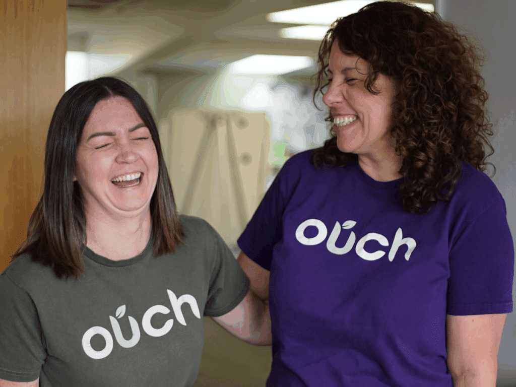Two employees from Ouch Learning and Development smiling together after learning about the mental health guidance from the HSE