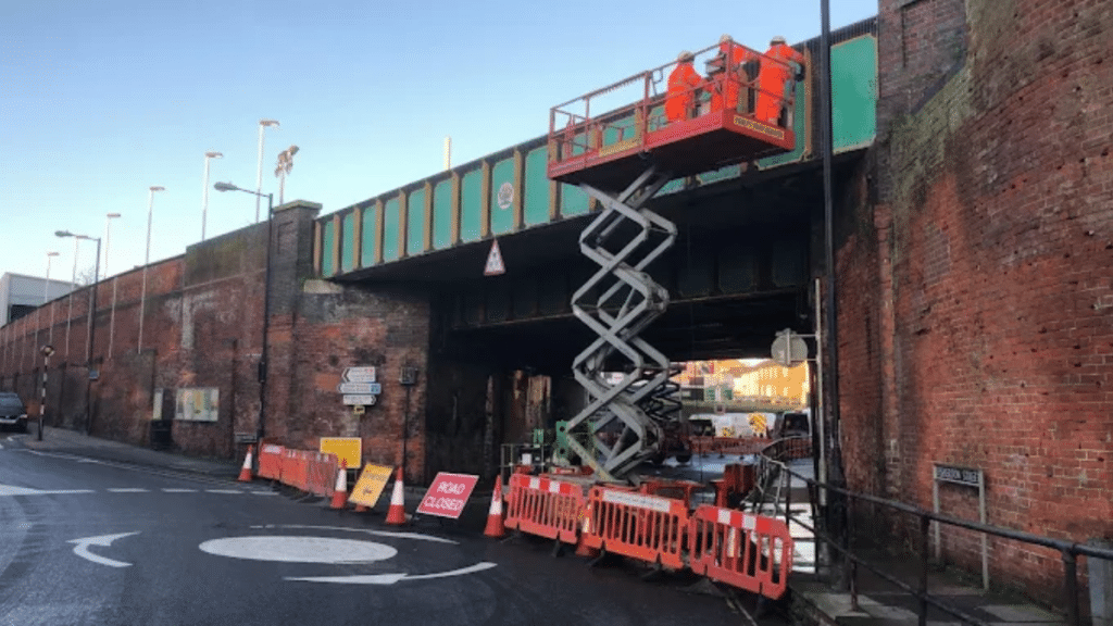 Construction workers using a scissor lift during infrastructure maintenance work
